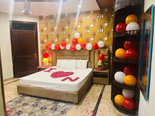 a bedroom with a bed with balloons on the wall at Madcrew Lodge in Islamabad