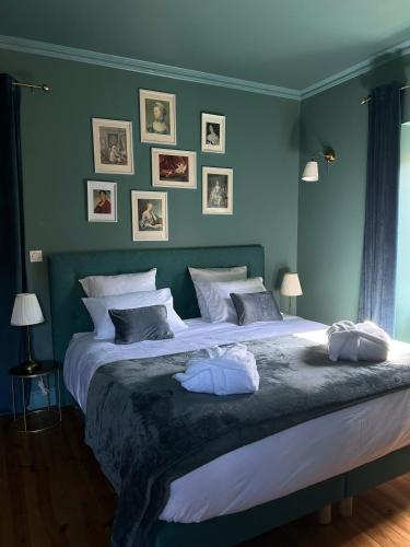 a bedroom with a large bed with blue walls at Moulin de Joumard, gîtes, chambres et table d'hôtes de charme , jacuzzi, sauna, piscine et bain nordique Etablissement 4 étoiles in Aubazat
