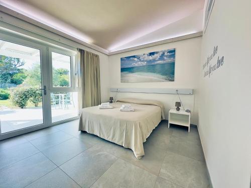 a bedroom with a bed and a large window at 309 Le Saline - Stintino in Stintino