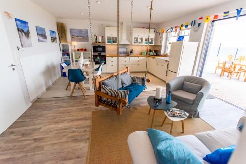 a living room with couches and chairs and a kitchen at Haus Seaside-Dahme in Dahme