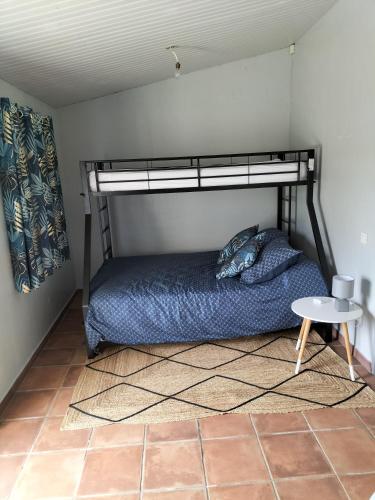 une chambre avec un lit superposé et une table dans l'établissement PETITE MAISON 2 PIECES POUR 4 à 5 personnes, à Le Boupère