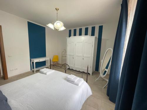 a bedroom with a white bed and blue and white stripes at Antica Residenza Colle in Nocera Umbra