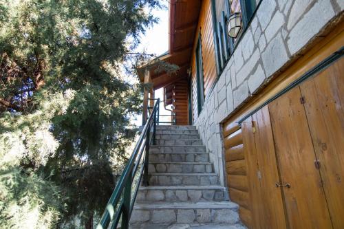 a staircase leading up to a house with a wooden door at Zeus-Village οικισμός φινλανδικών chalet με πισίνες & γυμναστήριο in Mólos