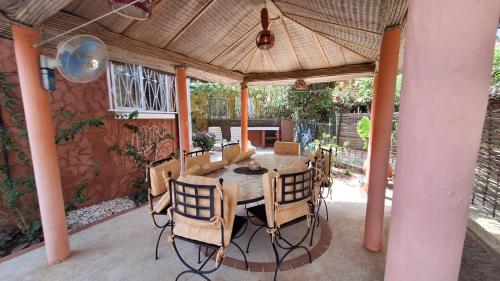 a dining room with a table and chairs on a patio at Safari Village - Case73 in Saly Portudal