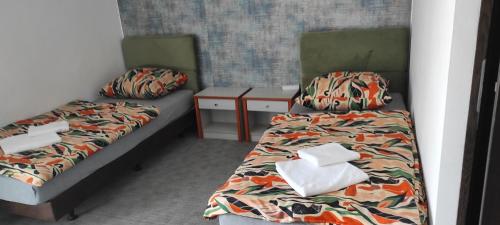 twee bedden in een kleine kamer met rokken bij Hot Elf Pokoje Gościnne in Świnoujście