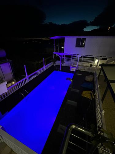 a swimming pool lit up in blue at night at Qeparo Napolon Complex in Qeparo
