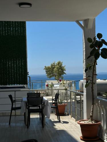 a balcony with a table and chairs and the ocean at Qeparo Napolon Complex in Qeparo