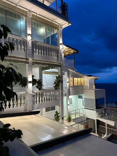 a house with a view of the ocean at night at Qeparo Napolon Complex in Qeparo