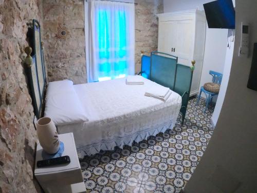 sypialnia z białym łóżkiem i oknem w obiekcie Dommu de Nannai Moro: Camera con bagno e balcone w mieście Baunei