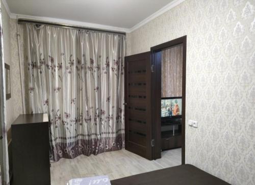 sala de estar con TV y tocador en Уютная двухкомнатная квартира в Актобе, en Aktobe
