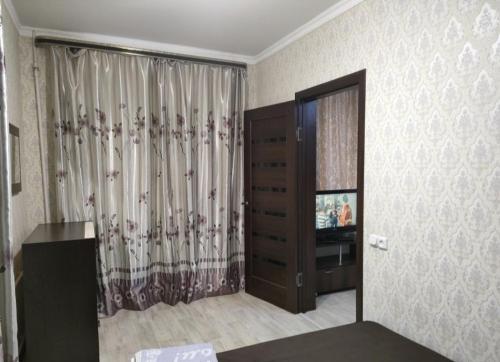 a living room with a television and a dresser at Уютная двухкомнатная квартира в Актобе in Aktobe