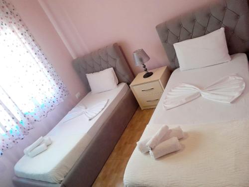 2 łóżka w małym pokoju z oknem w obiekcie George's Apartment w Gjirokastrze