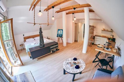 an attic bedroom with a bed and a table at River House Radolca in Radovljica
