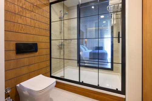 ギュンドガンにあるBaia Bodrum Hotelのバスルーム(ガラス張りのシャワー、トイレ付)
