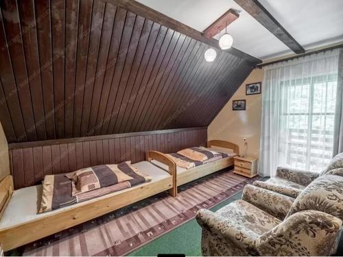 sypialnia z 2 łóżkami i kanapą w obiekcie Kolędówka Rest w Zawoi