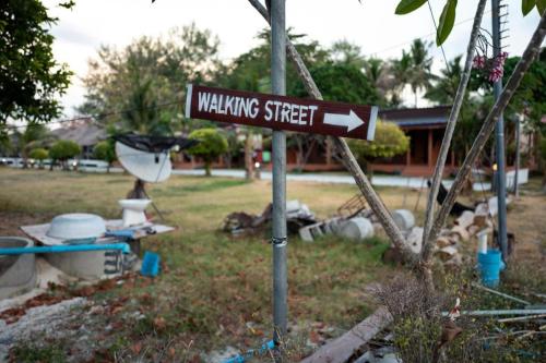 a street sign on a pole in a yard at The Green Hotel in Ko Lipe