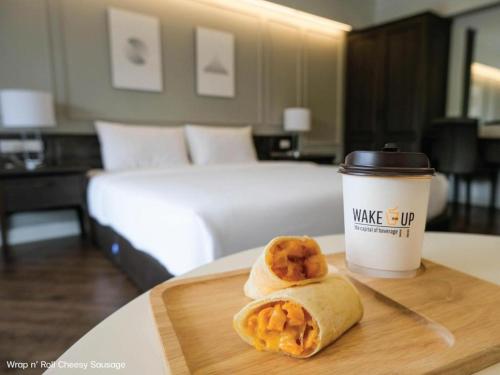 un burrito de desayuno y una taza de café en una habitación de hotel en B2 Hat Yai Rat Uthit Boutique & Budget Hotel, en Hat Yai