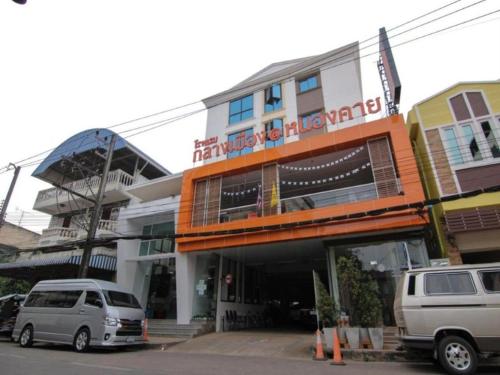 a building with two cars parked in front of it at Klang Muang @ Nongkhai Hotel in Nong Khai