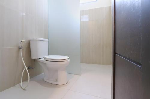 a bathroom with a toilet and a shower stall at Super OYO Balitone Residence in Denpasar