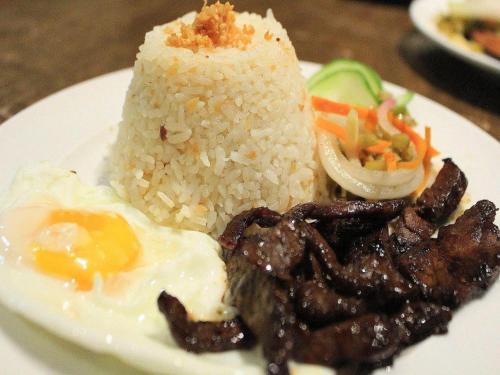 une plaque de nourriture à base de riz, de viande et de légumes dans l'établissement Filigans Hotel, à Puerto Princesa
