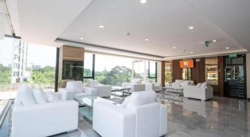 uma sala de estar com mobiliário branco num edifício em B2 Korat Premier Hotel em Ban Liap