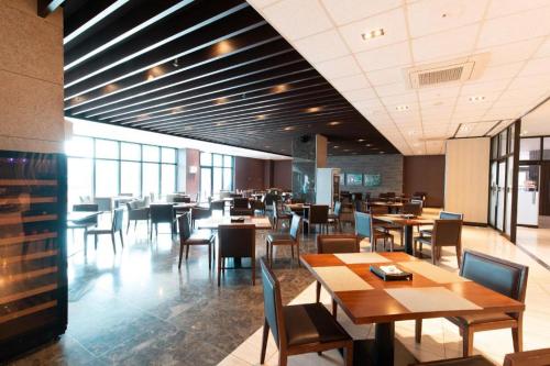 a restaurant with wooden tables and chairs and tablesearcher at Ebenezer Hotel in Jeju