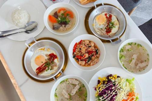 una mesa cubierta con cuencos de diferentes tipos de alimentos en The Room Hotel en Ban Nong Puk