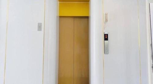 uma porta com uma caixa amarela em cima em The Room Hotel em Ban Nong Puk