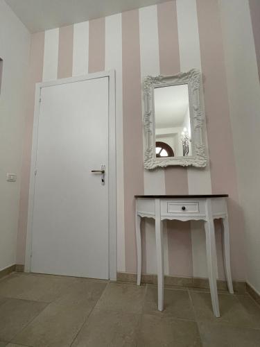 a room with a white door and a table with a mirror at Antica Residenza Colle in Nocera Umbra