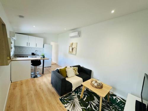 un salon avec un canapé et une table dans l'établissement Le Patio - Maison avec Jardin - WIFI, à Bègles