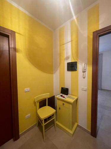 a yellow room with a desk and a chair at Antica Residenza Colle in Nocera Umbra