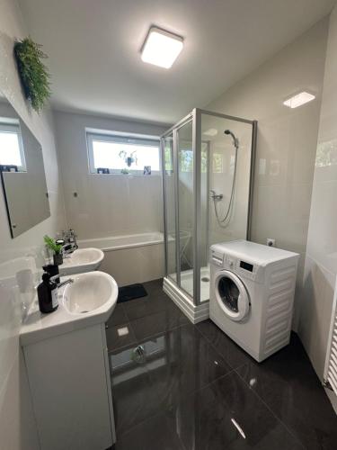 a bathroom with a sink and a washing machine at Panorama Apartments Presov in Prešov