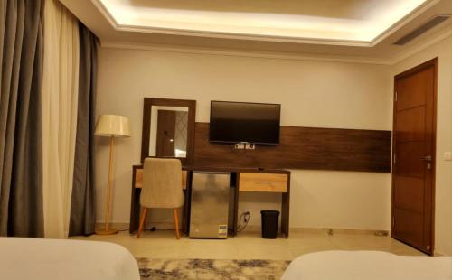 a hotel room with a television on a wall at Grand Plaza Sheikh Zayed in Kafr Abū ʼumaydah