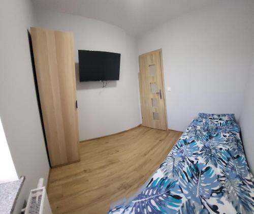 Schlafzimmer mit einem Bett und einem Flachbild-TV in der Unterkunft ApartHotel2 in Bystrzyca Kłodzka