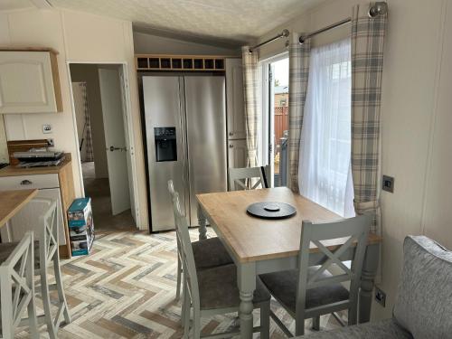 a kitchen and dining room with a table and chairs at Kingfisher Lodge Long Acre Holiday Park in Evesham