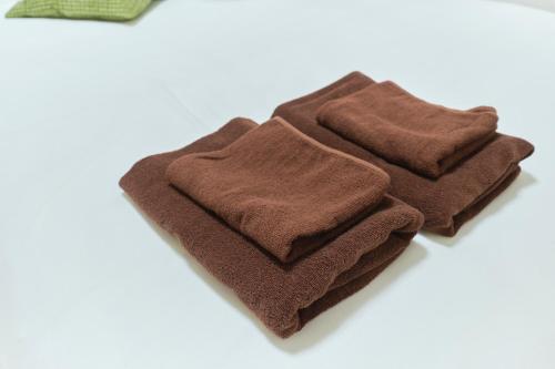 a pile of brown towels sitting on a white surface at J-ARC Akebonobashi in Tokyo