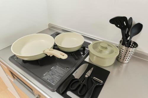 a stove top with two bowls and utensils on it at J-ARC Akebonobashi in Tokyo