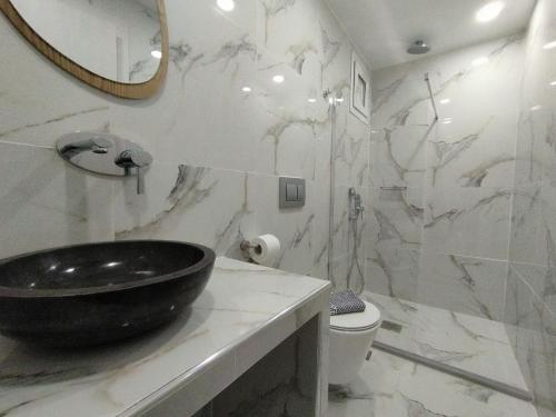 a bathroom with a black sink and a toilet at Rigas Hotel Skopelos in Skopelos Town