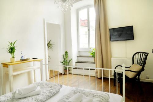a bedroom with a bed and a chair and a window at Art Hotel & Hostel in Passau