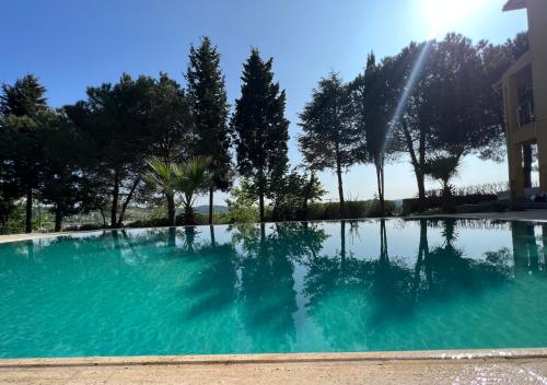 een zwembad van blauw water met bomen op de achtergrond bij Özel Havuzlu Bahçeli Müstakil Villa in Sile