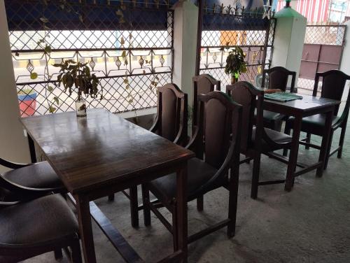a row of wooden tables and chairs in a restaurant at Jayalaxmi Hotel and lodge in Birātnagar