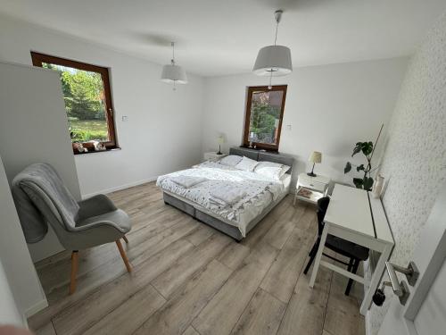 a bedroom with a bed and a desk and a chair at Przygórze - dom w Górach Sowich in Przygórze