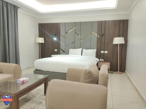 1 dormitorio con 1 cama, mesa y sillas en Grand Plaza Sheikh Zayed en Kafr Abū ʼumaydah
