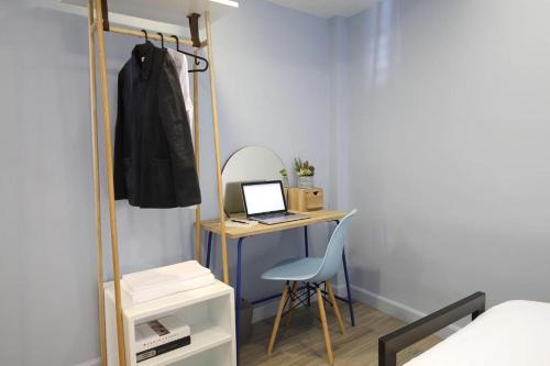 a bedroom with a desk with a laptop and a chair at Simply Sleep Hostel in Bangkok