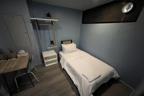 a small bedroom with a bed and a desk at Simply Sleep Hostel in Bangkok