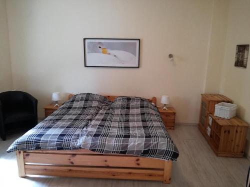 ein Schlafzimmer mit einem Bett mit einer karierten Decke darauf in der Unterkunft Ferienwohnung Annika mit Sauna in Zinnowitz