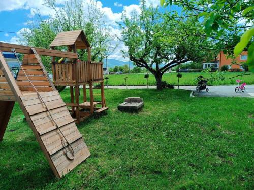 a park with a playground with a wooden swing at House Mila in Korenica