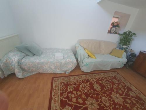 a living room with a couch and a bed at Habitaciones Casa Santander Playa Valdenoja in Santander