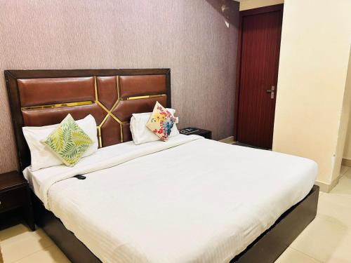 una camera da letto con letto, lenzuola e cuscini bianchi di Hotel Golden Apple a Prayagraj