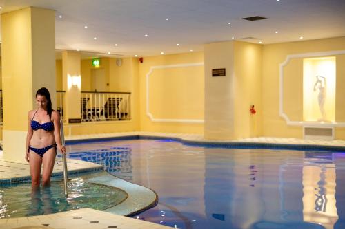 a woman in a bikini standing in a swimming pool at The Grand Hotel in Eastbourne